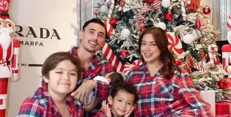 Jessica Iskandar kompak mengenakan piyama kotak-kotak warna merah dengan suami dan ketiga anak-anaknya. Keluarga ini pun berfoto di depan pohon natalnya tahun ini. [@inijedar]
