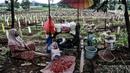 Pedagang bunga tertidur di dekat komplek makam protokol Covid-19 di TPU Bambu Apus, Jakarta, Selasa (2/3/2021). TPU Bambu Apus kini tidak lagi menampung pemakaman jenazah protokol Covid-19 akibat lahan di dua blok sudah penuh dan dialihkan ke TPU Srengseng Sawah. (merdeka.com/Iqbal S Nugroho)