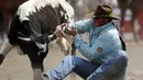 Jake Rinehart dari Highmore, South Dakota, berusaha meaih tanduk sapi liar di festival rodeo Calgary Stampede di Alberta, Kanada, (6/7/2014). (REUTERS/Todd Korol)