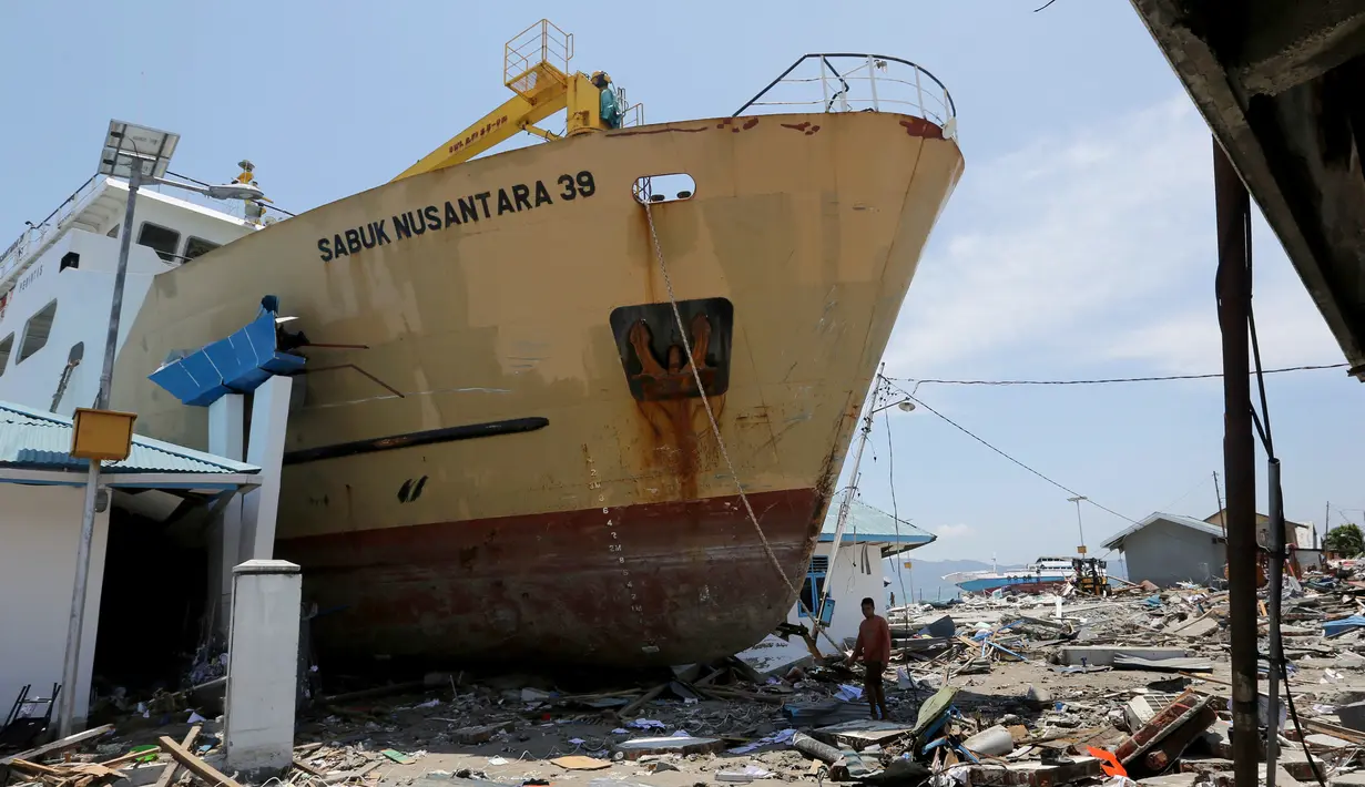 KM Sabuk Nusantara 39 terdampar di antara rumah warga setelah tsunami melanda Palu dan Donggala, Sulawesi Tengah, Selasa (2/10). Anak buah kapal (ABK) KM Sabuk Nusantara 39 yang berjumlah 29 orang selamat. (AP Photo/Tatan Syuflana)