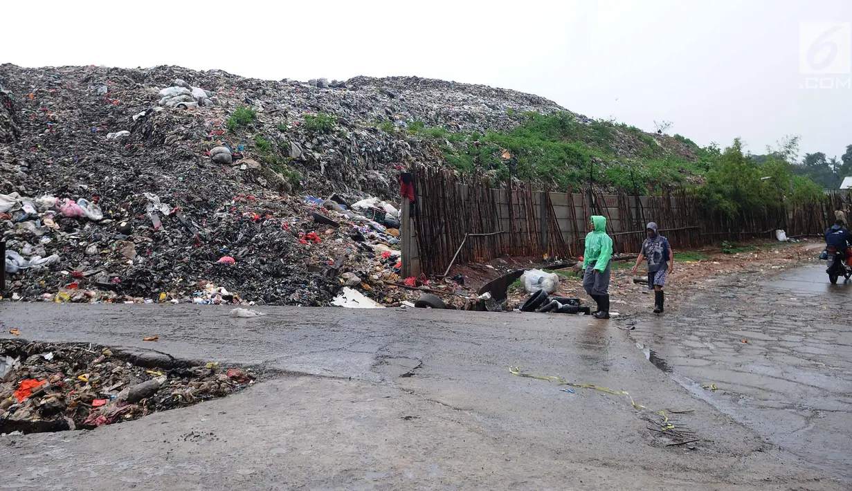 Warga melintas di tempat pembuangan akhir (TPA) Burangkeng, Bekasi, Jawa Barat, Selasa (22/1). TPA Burangkeng terbagi dalam empat zona: A, B, C, dan D. (Liputan6.com/Herman Zakharia)