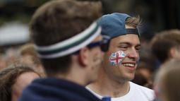 Seorang fans dengan gambar bendera Inggris sedang antri memasuki lapangan guna menonton Tenis Wimbledon Championships 2016 di The All England Lawn Tennis Club, Wimbledon,  London, (27/6/2016). (AFP/Adrian Dennis)
