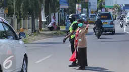 Anggota pramuka dan polisi mengatur lalu lintas jalur mudik di Cirebon, Jawa Barat, Jumat (1/7). Sebanyak 3.000-4.000 anggota pramuka Kwartir Daerah dikerahkan untuk membantu polisi memberikan pelayanan pada pemudik. (Liputan6.com/Angga Yuniar)