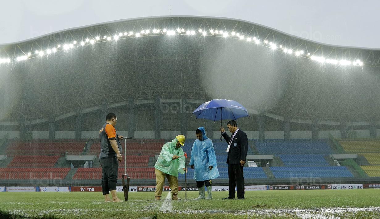 Petugas membuat lubang resapan untuk menguras air yang menggenangi lapangan di Stadion Patriot, Bekasi, Senin (13/11/2017). Drainase yang buruk menyebabkan lapangan terendam air. (Bola.com/M Iqbal Ichsan)