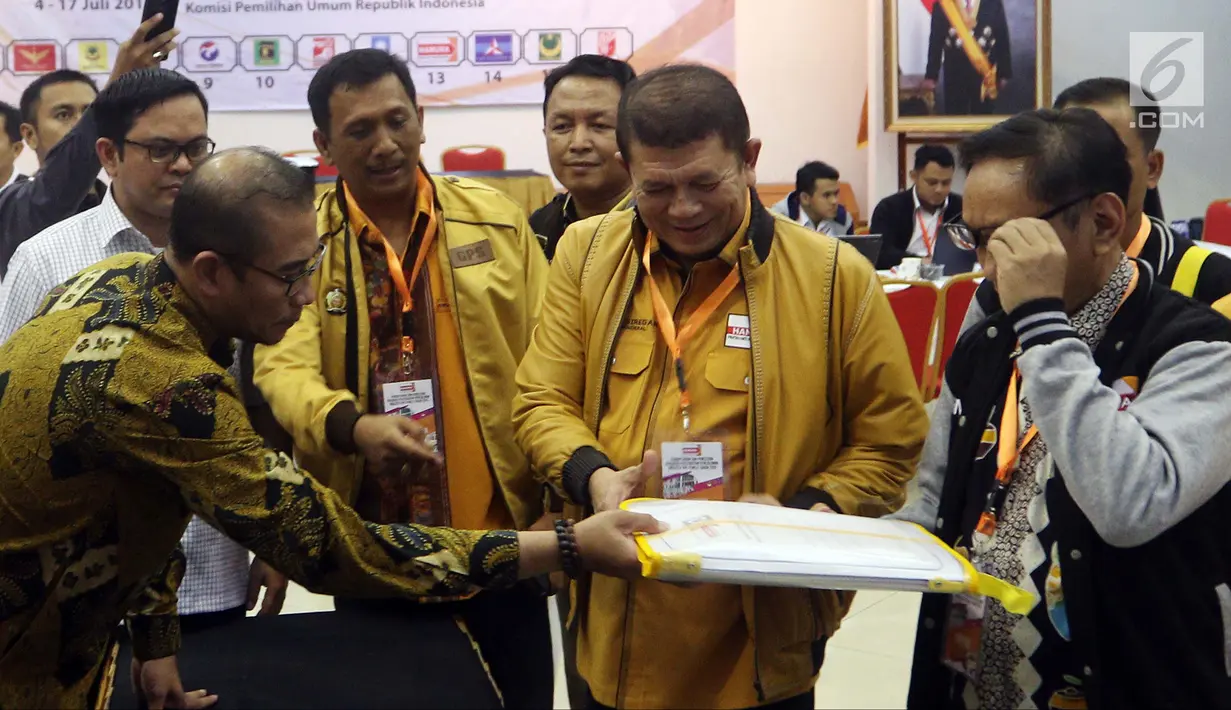 Sekjen Partai Hanura Harry Lontung Siregar (tengah) menyerahkan berkas pendaftaran bakal calon legislatif kepada Komisioner KPU Hasyim Asy'ari (kiri) di KPU, Jakarta, Selasa (17/7). (Liputan6.com/JohanTallo)