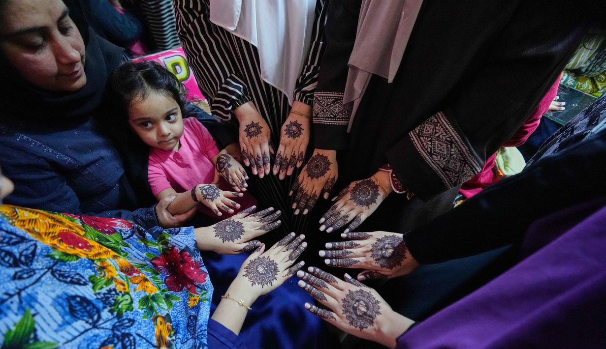 Sehari sebelum Idul Fitri merupakan puncak penggunaan henna bagi masyarakat Pakistan. Tampak dalam foto, para wanita memperlihatkan tangan mereka yang dihiasi dengan 'Henna' tradisional menjelang perayaan Idul Fitri, yang menandai berakhirnya bulan suci Ramadan, di Rawalpindi, Pakistan, Rabu, 18 Maret 2026. (AP Photo/Anjum Naveed)