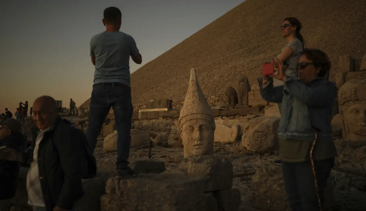 Gambar pada 23 September 2019 memperlihatkan wisatawan berfoto di Gunung Nemrut, Provinsi Adiyaman di Turki bagian tenggara. Gunung Nemrut, telah menjadi  Situs Warisan Dunia UNESCO sejak 1987 dan merupakan salah satu Taman Nasional terpenting di Turki. (AP/Emrah Gurel)