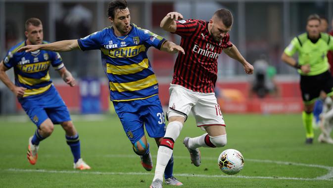 Penyerang AC Milan, Ante Rebic membawa bola dari kawalan pemain Parma, Matteo Darmian pada pertandingan lanjutan Liga Serie A Italia di Stadion San Siro di Milan, Italia (15/7/2020). AC Milan menang telak 3-1 atas Parma. (AP Photo/Luca Bruno)