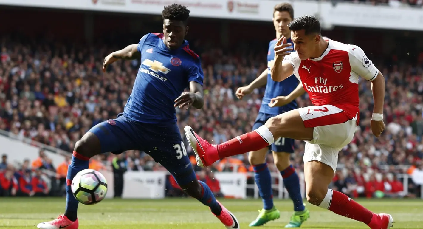 tendangan dalam kawalan bek Manchester United, Axel Tuanzebe, dalam laga lanjutan Premier League, di Stadion Emirates, Minggu (7/5/2017). (AFP/Adrian Dennis)