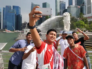 Para pemain timnas Indonesia U-23 ber-selfie di Merlion Park, Singapura, Jumat (5/6/2015). Para penggawa Garuda Muda bersantai sejenak usai melaksanakan ibadah salat Jumat di Masjid Sultan, Bugis, Singapura. (Liputan6.com/Helmi Fithriansyah)