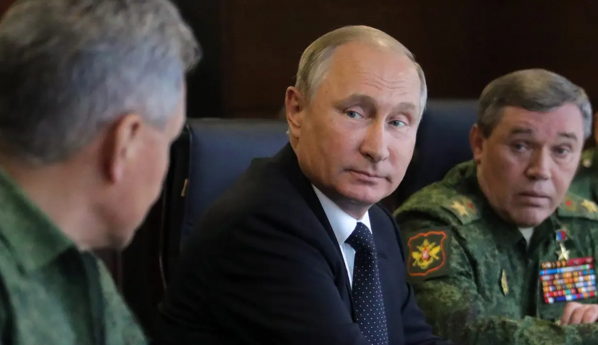 Presiden Rusia Vladimir Putin (tengah) saat menyaksikan latihan militer Rusia Zapad-2017 dengan Belarus di Luzhsky di wilayah Leningrad (18/9). Latihan ini diikuti 13.000 personel Rusia dan Belarusia. (AFP Photo/Sputnik/Mikhail Klimentyev)