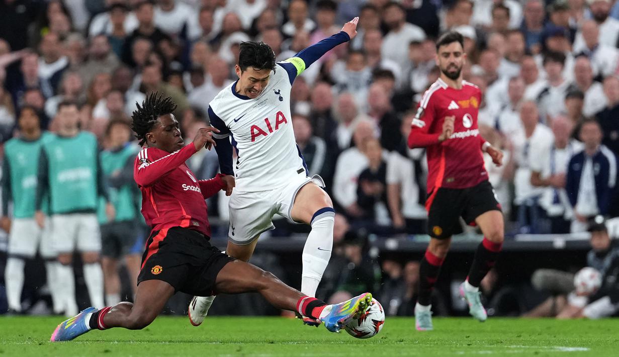 Pemain Tottenham Hotspur, Son Heung-min (tengah) berebut bola dengan pemain Manchester United, Patrick Dorgu dalam laga final Liga Europa 2024/2025 di Stadion San Mames, Bilbao, Spanyol, Kamis (22/05/2025) WIB. (AFP/Cesar Manso)