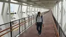 Warga melintasi jembatan penyeberangan (Skybridge) yang menghubungkan Stasiun LRT Velodrome dengan Halte Transjakarta Pemuda di Rawamangun, Jakarta, Senin (29/7/2019). Skybridge ini bertujuan memudahkan integrasi penumpang LRT menuju Transjakarta atau sebaliknya. (Liputan6.com/Immanuel Antonius)