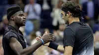 Petenis Swiss, Roger Federer bersalaman dengan Frances Tiafoe dari Amerika Serikat usai pertandingan turnamen tenis AS Terbuka 2017 di New York (29/8). Federer menang 4-6, 6-2, 6-1, 1-6, 6-4. (AP Photo/Julio Cortez)