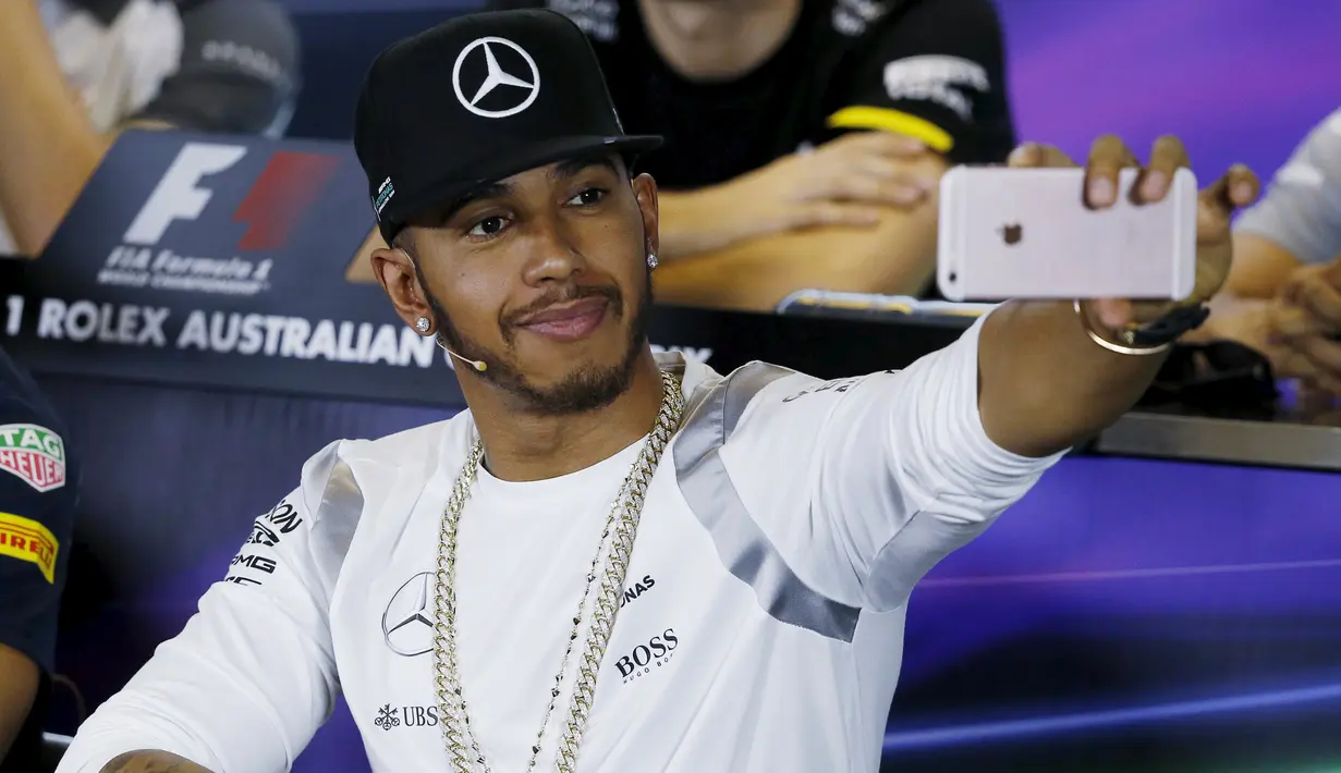 Pembalap F1 dari tim  Mercedes, Lewis Hamilton berselfie saat konferensi pers Formula One Grand Prix di Melbourne, Australia, (17/03/16). Pembalap asal Inggris ini merupakan salah satu pebalap yang eksis di media sosialnya. (REUTERS/Brandon Malone)