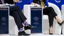 Kaus kaki PM Kanada Justin Trudeau terlihat saat sesi bersama peraih Nobel Malala Yousafzai pada acara tahunan World Economic Forum di Davos, Swiss, Kamis (25/1). Kaus kaki terlihat kala dia mengangkat salah satu kakinya. (Fabrice COFFRINI/AFP)