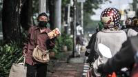 Pedagang asongan menjajakan dagangannya di lampu merah kawasan Manggarai, Jakarta, Minggu (18/10/2020). Institute for Development of Economics and Finance (Indef) memproyeksikan jumlah penduduk miskin naik 1,63 juta jiwa atau 0,56 persen selama masa pandemi Covid-19. (merdeka.com/Iqbal S. Nugroho)