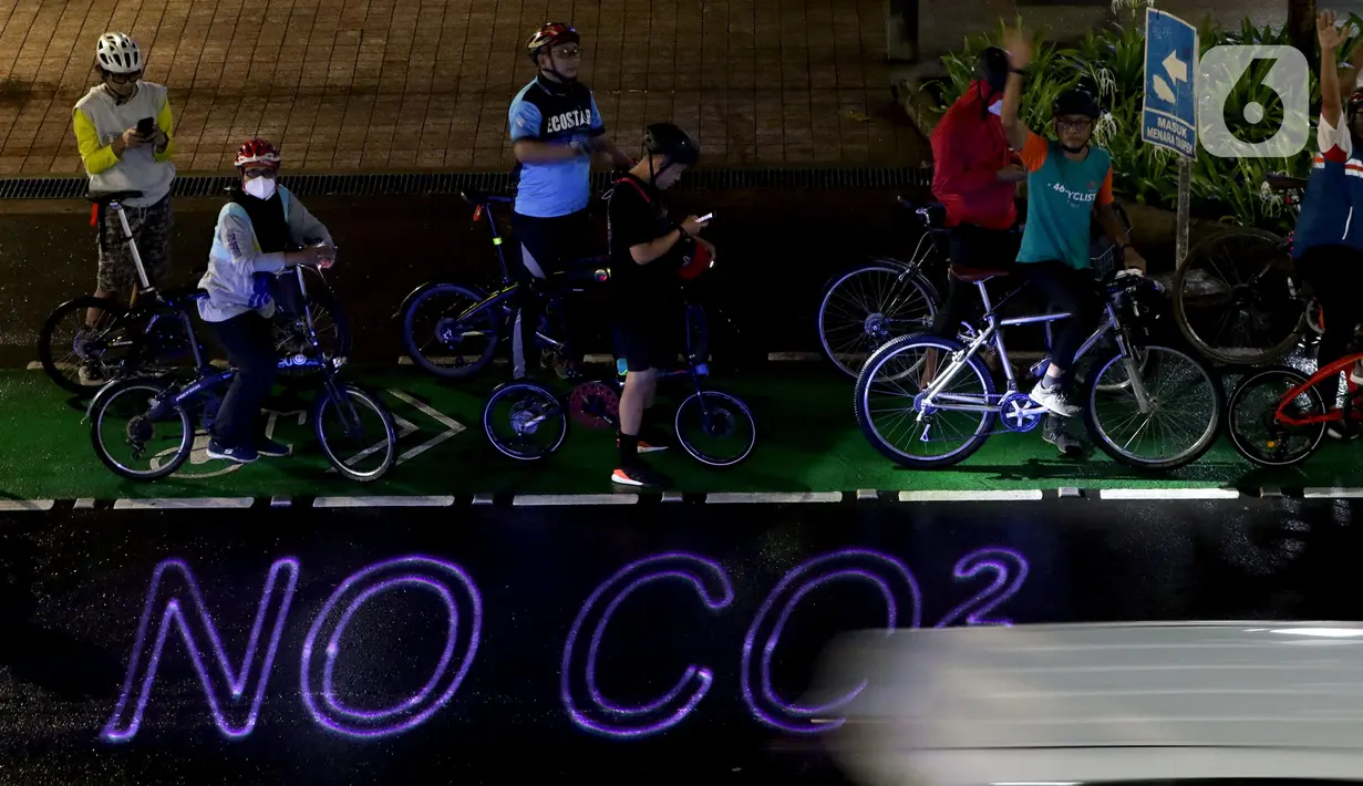 Pegiat bersepeda dan aktivis pecinta lingkungan saat aksi gowes Kelap Kelip Jakarta Night Ride #NOP26 di Kawasan Dukuh Atas, Jalan Jenderal Sudirman, Jakarta, Jumat (26/11/2021). Aksi bertujuan untuk mendorong penggunaan sepeda sebagai solusi transportasi nol emisi. (Liputan6.com/Helmi Fithriansyah)