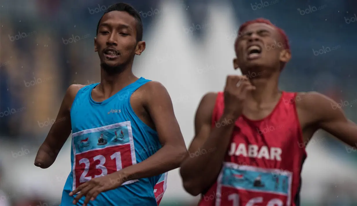 Atlet Jawa Tengah, Ahmad Zein (kiri), menyelesaikan lomba nomor 200 meter T 47 putra pada Peparnas XV di Stadion Gelora Bandung Lautan Api, Bandung, Kamis (20/10/2016). (Bola.com/Peksi Cahyo) 