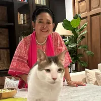 Foto terbaru, Titiek mengenakan baju pink bermotif dipadukan selendang warna serasi dan aksesori kalung mutiara saat bertemu dengan Bobby kucing kesayangan Prabowo. [@titieksoeharto]