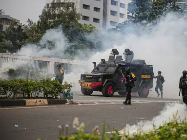 Polisi mengerahkan kendaraan taktis water cannon dan menembakkan gas air mata ke arah para pengunjuk rasa di depan pintu gerbang gedung DPR RI Jakarta, Senin (11/4/2022). Situasi mulai memanas akibat sejumlah pengunjuk rasa melempari petugas dengan berbagai benda lainnya (Liputan6.com/Faizal Fanani)