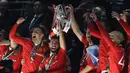 Pemain Manchester United, Bruno Fernandes mengangkat trofi setelah memenangkan final Carabao Cup 2023 melawan Newcastle United yang berlangsung di Wembley Stadium, Minggu (26/2/2023) waktu setempat. (AFP/Adrian Dennis)