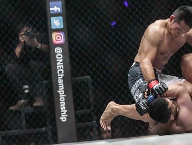 Dua petarung Indonesia Victorio Senduk (kiri) berusaha mengunci gerak Yohan Mulia Legowo (bawah) saat berlaga pada One Championship di Jakarta, Sabtu (20/1). Pada laga tersebut Victorio Senduk menang atas Yohan Mulia. (Liputan6.com/Faizal Fanani)