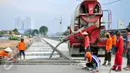 Pekerja melakukan penyemenan jalan inspeksi di Kalijodo, Jakarta, Kamis (14/4/2016). Jalan inspeksi selebar 7,5 meter yang terletak di samping Kali Angke diperkirakan akan rampung pada pertengahan April. (Liputan6.com/Yoppy Renato)