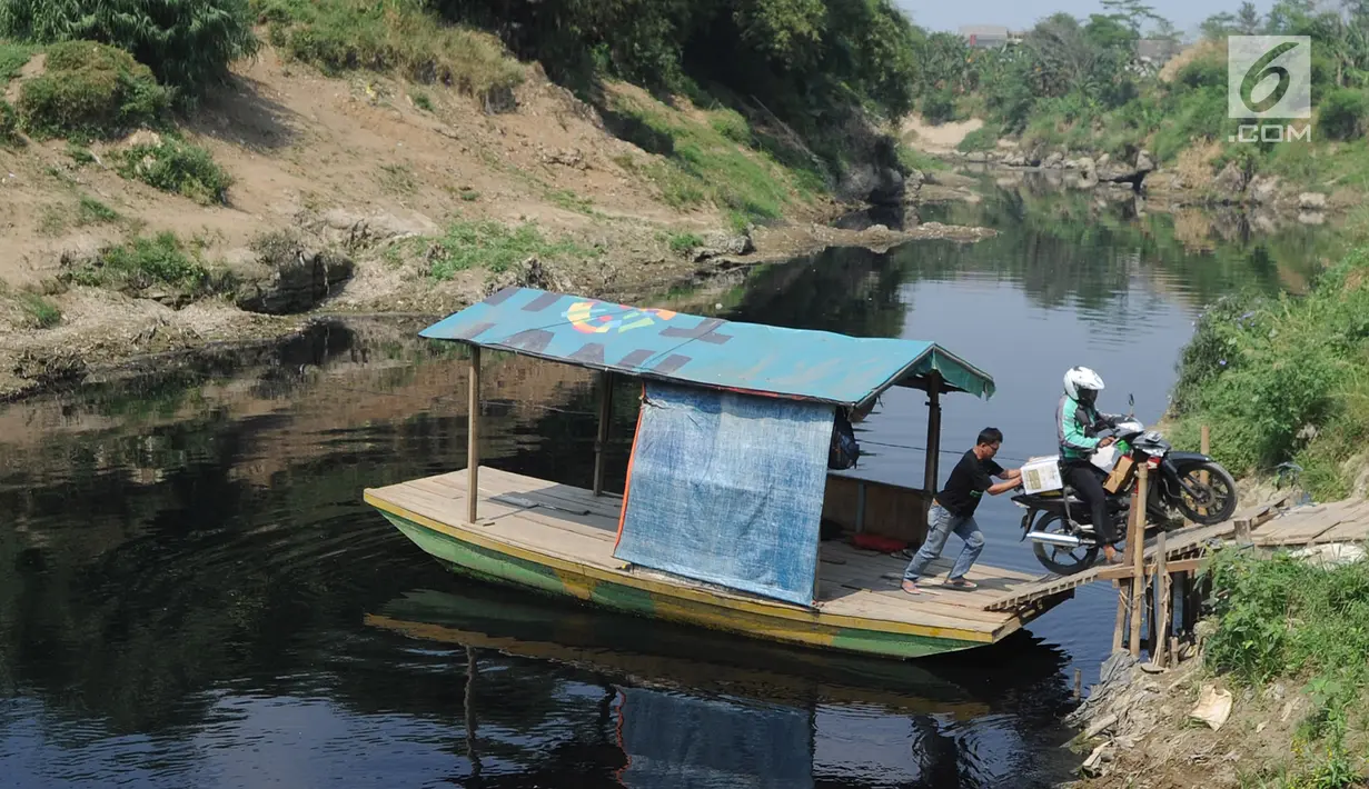 Pengendara motor menggunakan jasa penyeberangan perahu eretan di Sungai Cileungsi pebatasan Kabupaten Bogor-Kabupaten Bekasi, Bojong Kulur, Kabupaten Bogor, Jawa Barat, Selasa (23/7/2019). Perahu eretan tersebut digunakan warga sebagai jalan alternatif untuk menyeberang. (merdeka.com/Arie Basuki)
