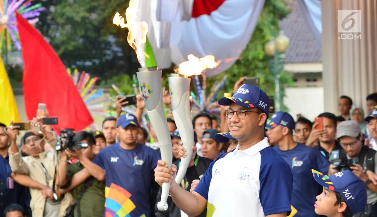 Gubernur DKI Jakarta, Anies Baswedan membawa Api Obor Asian Games 2018 setelah mengelilingi dari Jakarta Timur dan Jakarta Selatan di Balai Kota, Jakarta, Rabu (15/8). (Liputan6.com/Fery Pradolo)