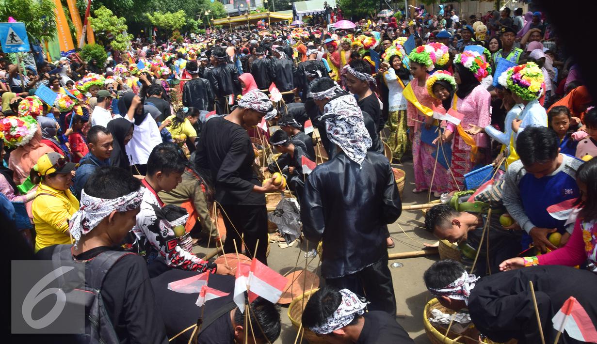 Ribuan orang memenuhi jalan Jenderal Sudirman di Indramayu,  Minggu, (9/10). Warga menyaksikan Tradisi Pawai Ngarot yang diikuti oleh ratusan pemuda dan gadis yang berusia 17 tahun. (Liputan6.com/Gholib)