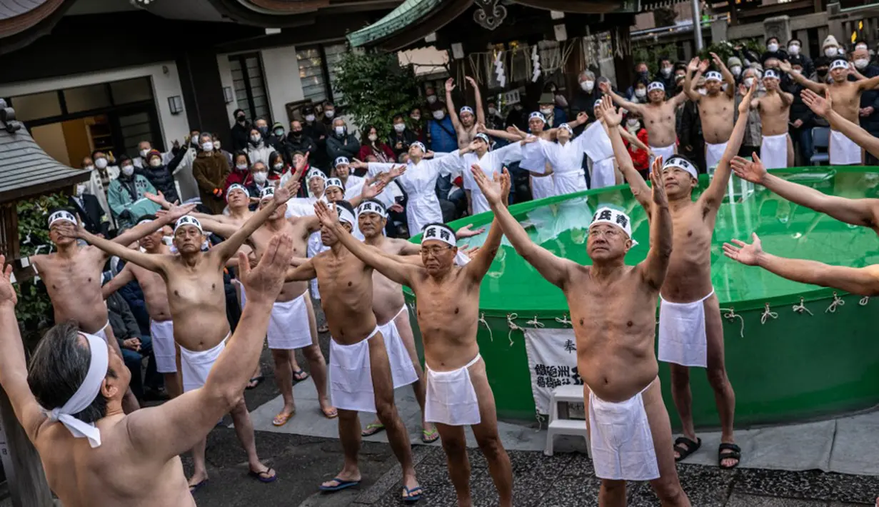 Penganut Shinto melakukan pemanasan sebelum mandi dengan air dingin di Kuil Teppozu Inari, Tokyo, Jepang, 8 Januari 2023. Ritual Tahun Baru ini dilakukan untuk memurnikan jiwa dan raga. (Philip FONG/AFP)