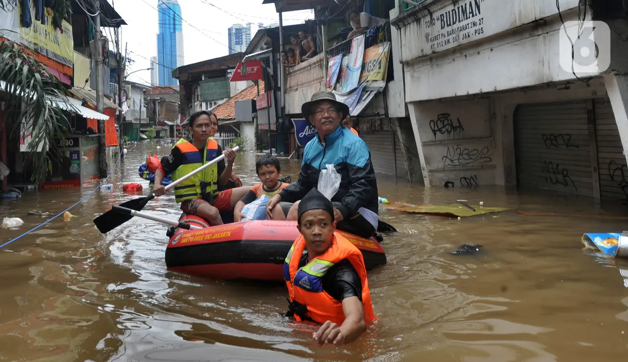 Petugas mengevakuasi warga korban banjir menggunakan perahu karet di kawasan Karet Pasar Baru Barat, Jakarta, Selasa (25/2/2020). Banjir yang terjadi sejak subuh akibat luapan Kanal Banjir Barat tersebut merendam ratusan rumah hingga setinggi dua meter. (merdeka.com/Arie Basuki)