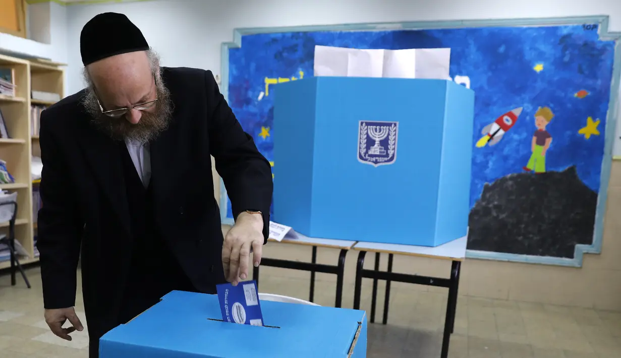 Pria Yahudi ultra-Ortodoks memberikan suaranya selama pemilihan parlemen Israel di Yerusalem (9/4). Warga Israel hari ini memberikan suara dalam pemilihan tingkat tinggi yang akan memutuskan masa jabatan PM Benjamin Netanyahu meskipun ada dugaan korupsi yang dilakukannya. (AFP Photo/Menahem Kahana)