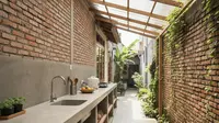 Desain Dapur Terbuka di Gang Sempit dengan Atap Fiber dan Meja Semen. Gemini