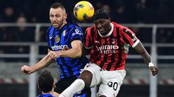 Pemain Inter Milan, Stefan de Vrij (kiri) berduel udara dengan pemain AC Milan, Tammy Abraham dalam laga lanjutan Liga Italia 2024/2025 di San Siro, Milan, Italia, Senin (03/02/2025) WIB. (AFP/Piero Cruciatti)