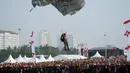 Salah satu peterjun wanita dari Komando Pasukan Khusus TNI AD bersiap mendarat di kawasan Tugu Monas, (31/8/2014). (Liputan6.com/Helmi Fithriansyah)