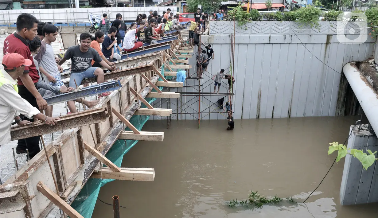 Warga melihat banjir yang merendam Underpass Senen, Jakarta, Selasa (25/2/2020). Hujan deras yang mengguyur Ibu Kota sejak dini hari tadi menyebabkan Underpass Senen terendam banjir setinggi dua meter sehingga mengakibatkan akses Cempaka Putih-Pasar Senen terputus. (merdeka.com/Iqbal Nugroho)