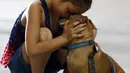 Reniah Knight memeluk anjingnya di NRG Arena di Houston (13/9). Relawan mengamankan 400 anjing dan 100 kucing untuk membantu menyatukan pemilik dengan hewan peliharaannya yang hilang akibat Badai Harvey. (Karen Warren/Houston Chronicle via AP)