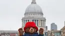 Seseorang yang mengenakan kostum Paddington Bear berpose dengan latar belakang Katedral St. Paul di London, Inggris (30/5). Karakter Paddington ini cukup terkenal di Inggis. (AP/Frank Augstein)