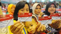 Warga menunjukkan KKS di Cibubur, Jakarta, Kamis (23/2). Keluarga kurang mampu yang menerima Bantuan Pangan Non Tunai dapat langsung menggunakan KKS untuk berbelanja bahan pokok di e-warung yang berada di lingkungan mereka. (Liputan6.com/Angga Yunair)