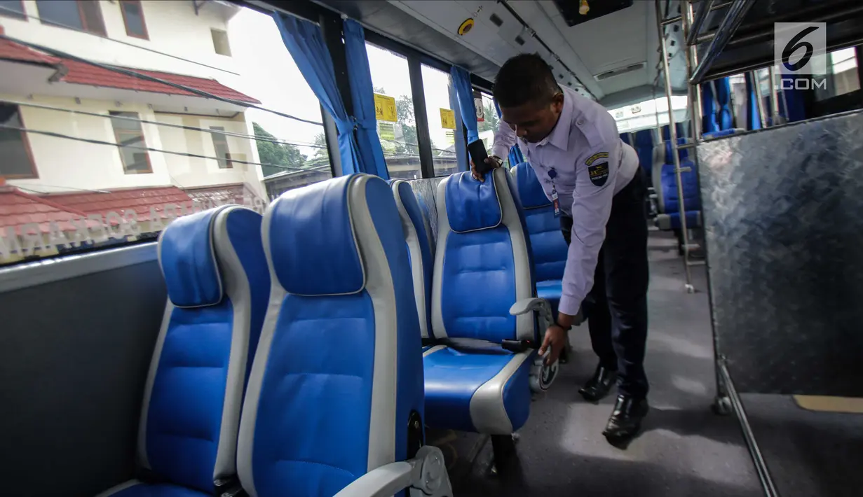 Petugas mengecek kondisi kursi dalam bus Transjabodetabek Premium milik Perum PPD saat menunggu calon penumpang di Tamini Square, Jakarta, Kamis (14/12). (Liputan6.com/Faizal Fanani)