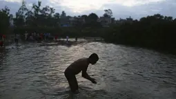 Seorang pria Nepal mandi air suci di sungai Bagmati selama festival Kuse Aunsi di Kathmandu (30/8/2019). Kuse Aunsi sebagai bentuk penghormatan kepada ayah bimbingan dan ajarannya dalam kehidupan. (AP Photo/Niranjan Shrestha)