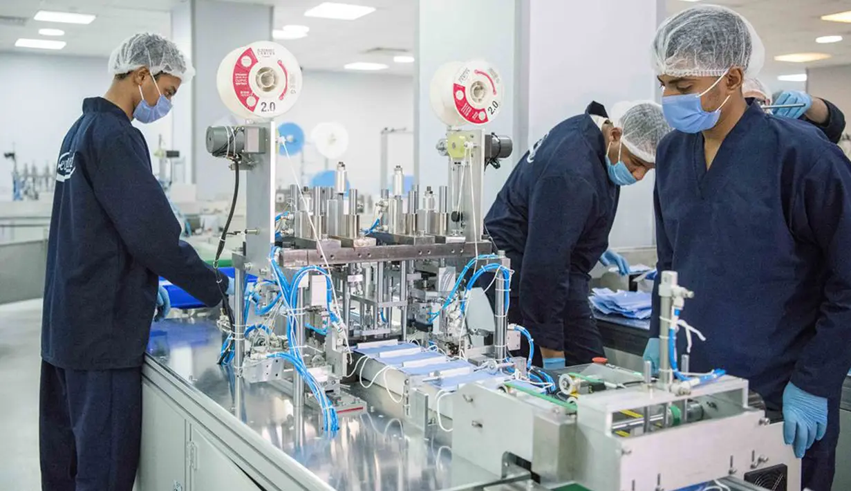 Orang-orang bekerja di sebuah pabrik yang memproduksi masker medis di Kairo, Mesir, pada 14 April 2020. Para karyawan bekerja siang dan malam untuk mengoperasikan lima mesin canggih yang dibawa dari China untuk memproduksi hingga 750.000 masker medis per hari. (Xinhua/Wu Huiwo)