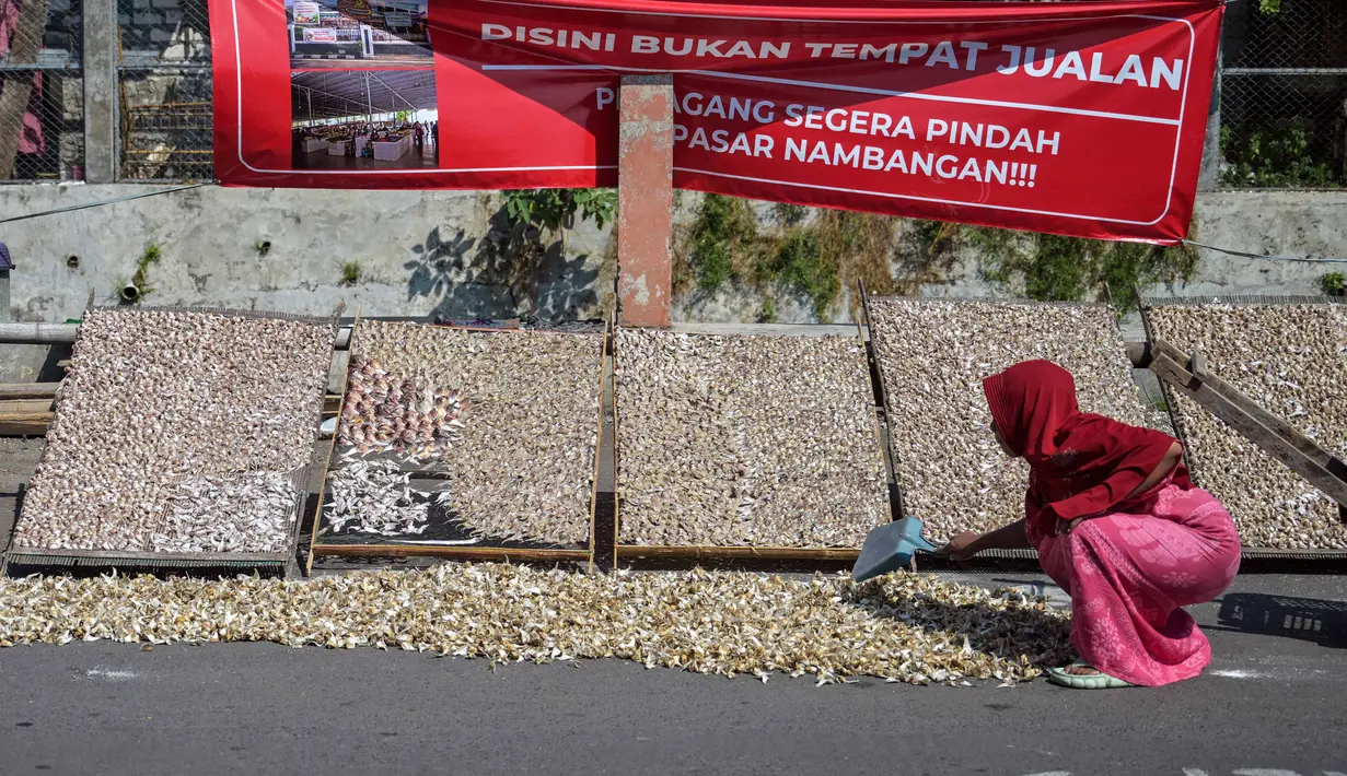 Dana tersebut telah disalurkan kepada sekitar 1,5 juta debitur di seluruh Indonesia dengan fokus utama pada sektor produksi dan usaha mikro. Tampak dalam foto, seorang wanita menjemur ikan asin di pinggir jalan, Surabaya, Jawa Timur, Rabu 6 Mei 2026. (JUNI KRISWANTO/AFP)