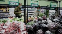 Orang-orang membeli makanan dan kebutuhan rumah tangga di sebuah supermarket di Beijing pada 25 April 2022. Kekhawatiran penguncian Covid memicu pembelian panik dan antrean panjang untuk pengujian massal di Beijing pada 25 April ketika otoritas China bergegas untuk membasmi wabah di ibu kota. (AFP/Noel Celis)