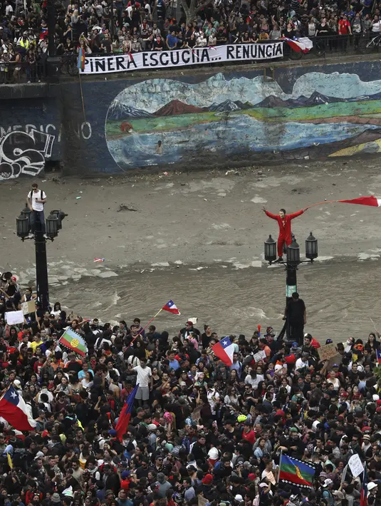 Warga berkumpul saat protes antipemerintah di Santiago, Chile, Jumat (25/10/2019). Ibu Kota Santiago lumpuh karena banyaknya jumlah demonstran. (AP Photo/Rodrigo Abd)