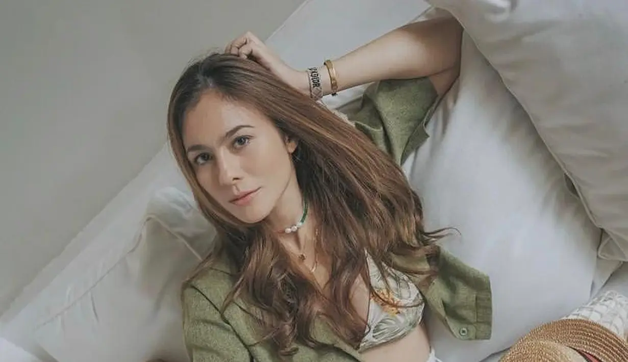 Kala liburan, kekasih Sabda Ahessa ini terlihat mengenakan bikini floral nuansa warna hijau, dipadukan dengan kemeja crop top warna olive, dan short pants warna putih. (Instagram/wulanguritno).