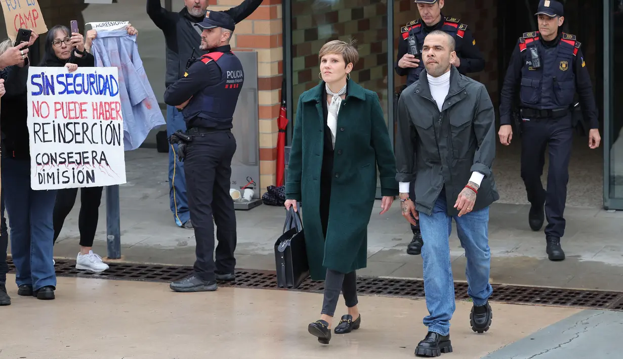 Pemain Brasil, Dani Alves (kanan) bersama pengacaranya, Ines Guardiola berjalan meninggalkan penjara Brians 2 di San Esteban Sasroviras, Barcelona, Spanyol, 25 Maret 2024. Alves bebas dari penjara setelah membayar uang jaminan 1 juta euro ke Pengadilan Barcelona. (AFP/Lluis Gene)
