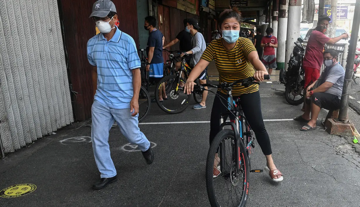 Seorang pekerja rumah sakit pemerintah mengendarai sepedanya yang baru dibeli di Manila pada 20 Mei 2020. Alat transportasi umum yang masih beroperasi dalam kapasitas terbatas membuat warga Filipina beralih ke sepeda saat berakhirnya masa karantina dan dimulainya periode New Normal. (Ted ALJIBE/AFP)